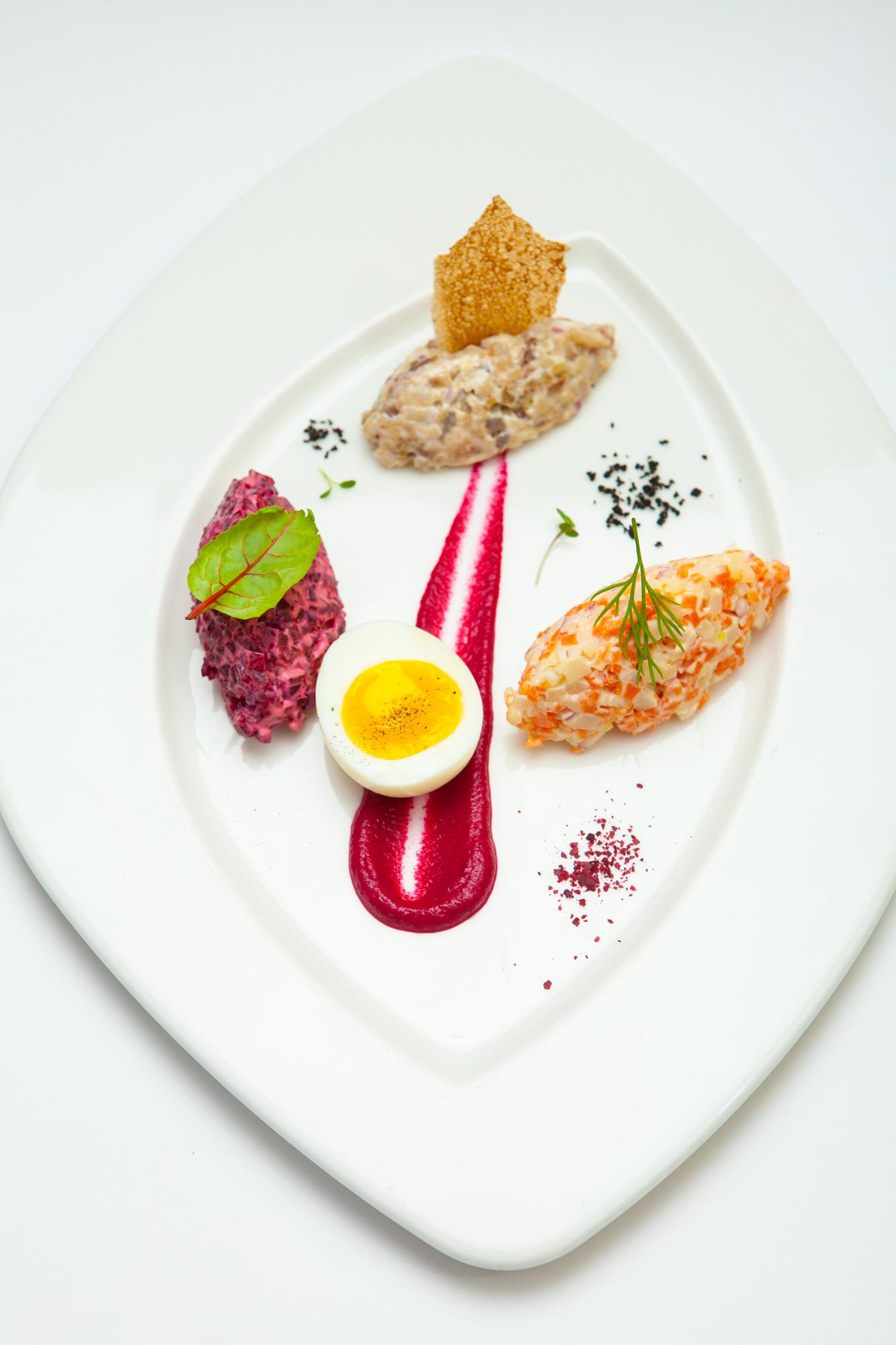 Chef plating a colorful dish in a modern kitchen